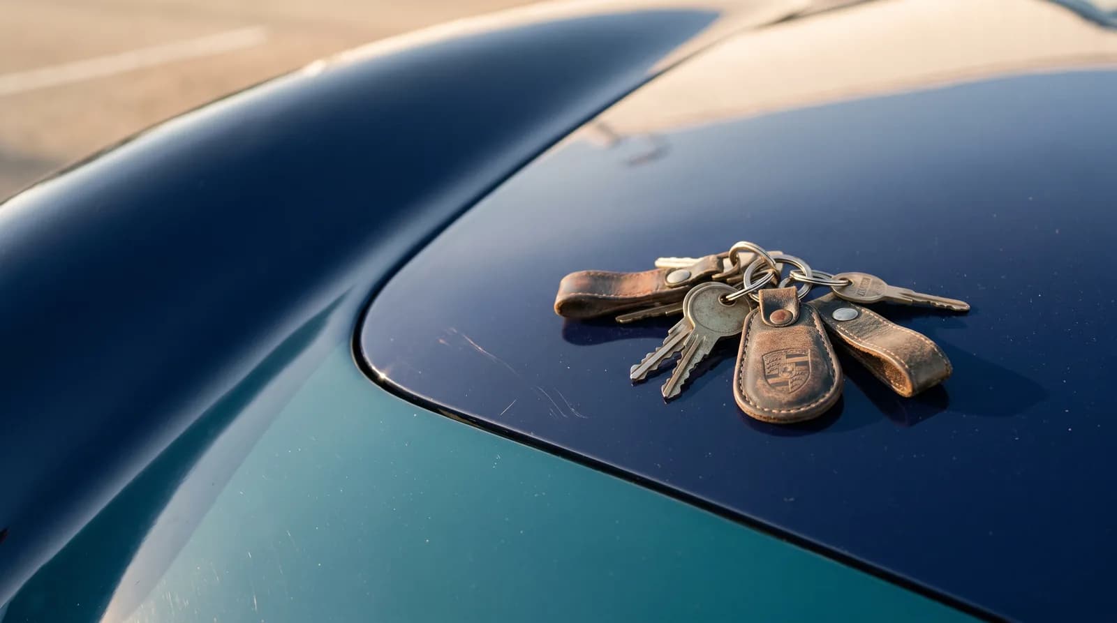 Juego de llaves sobre el cofre de un automóvil azul.